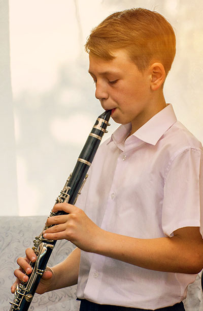 Boy blowing into Clarinet